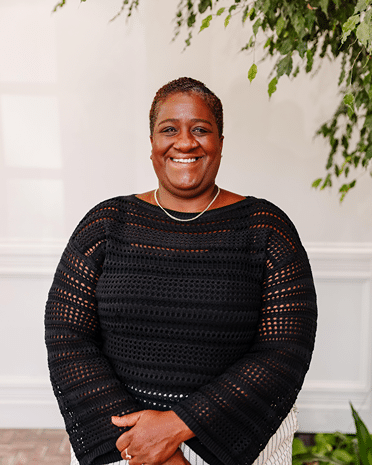 Stacia Ponce Rodriguez smiling woman in black sweater Professional headshot with a warm inviting expression