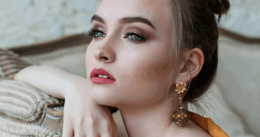 Heroin chic fashion Woman with bold eye makeup pink lipstick and statement earrings embodying the resurgence of the trend