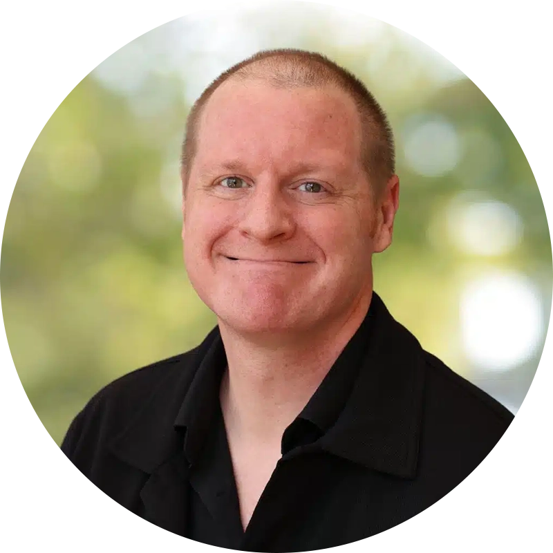 image17webp Silicon Valley Recovery Smiling man in a black collared shirt head and shoulders portrait outdoors with a blurred natural background